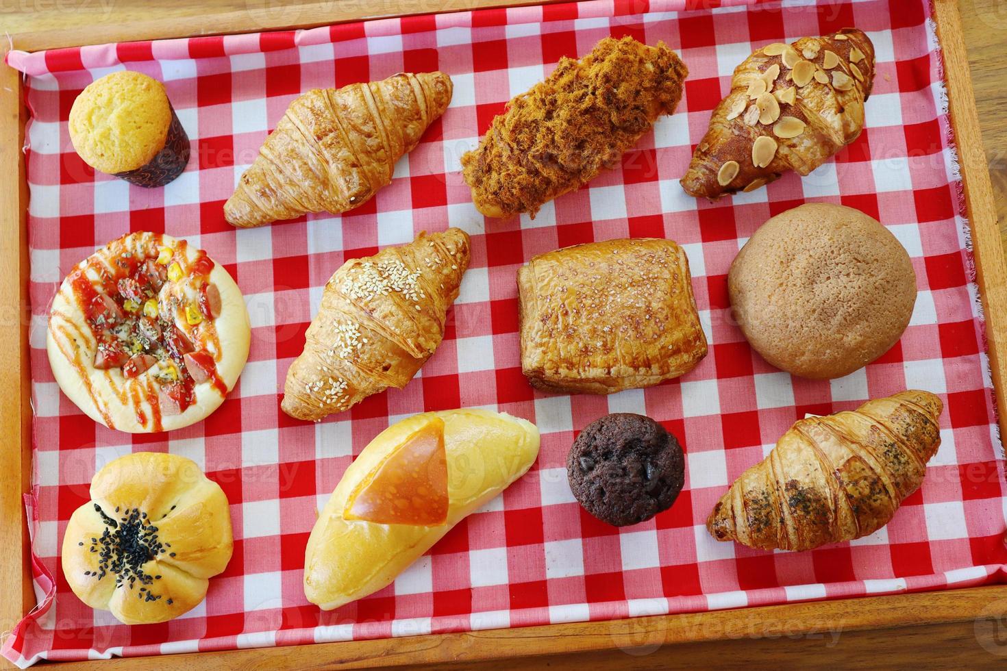 pão variado pão de queijo duplo, pão de feijão vermelho, muffin de choco, muffin de queijo, frango desfiado, croissant de leite de amêndoa, croissant de carne defumada, linguiça bovina foto