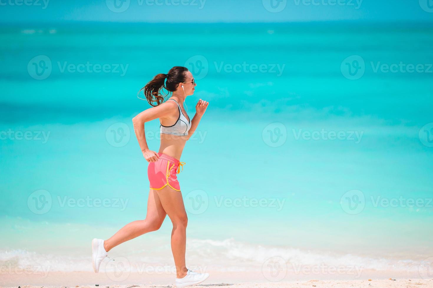 ajuste a jovem mulher na praia tropical em roupas esportivas foto