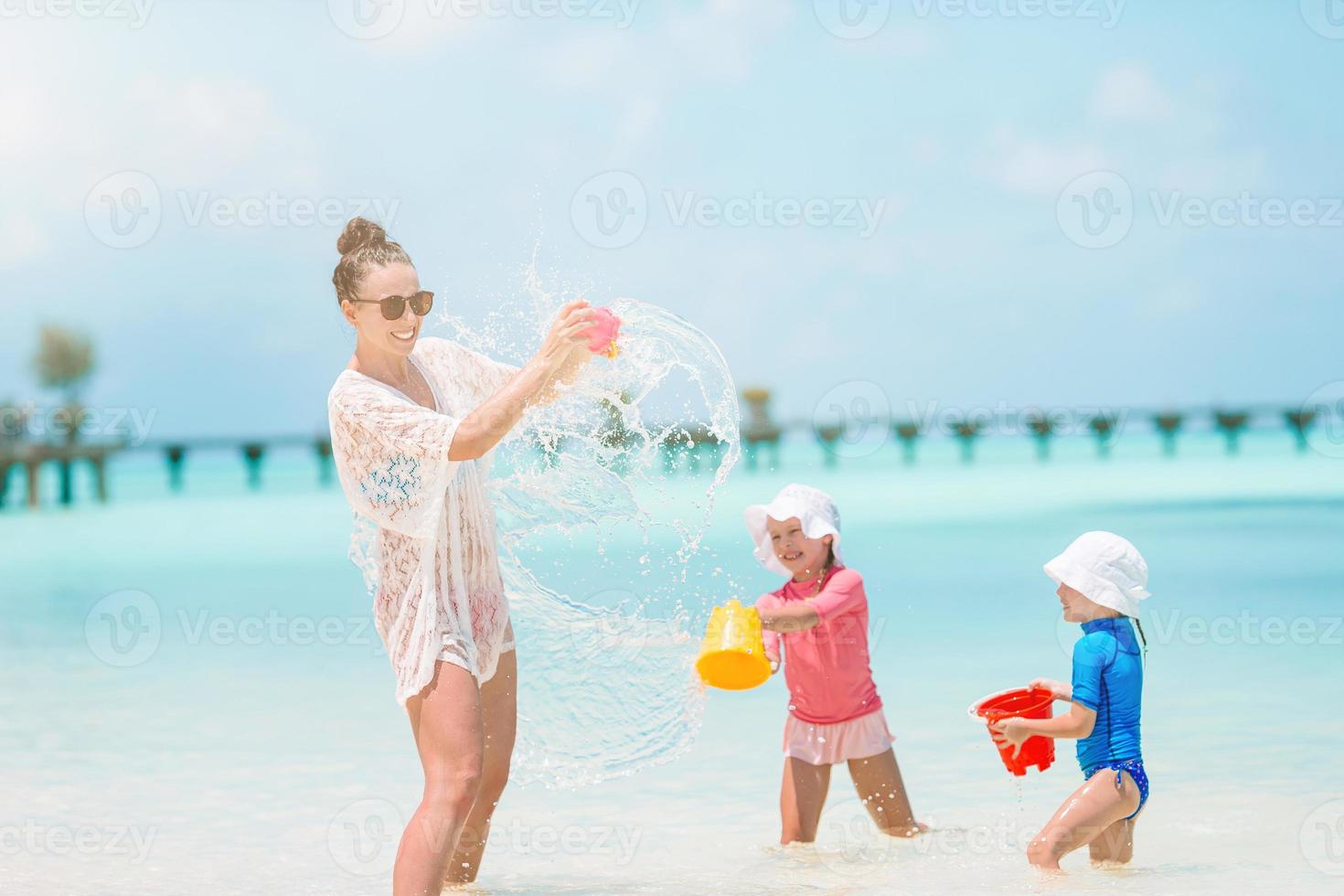 linda mãe e filhas na praia do caribe aproveitando as férias de verão. foto