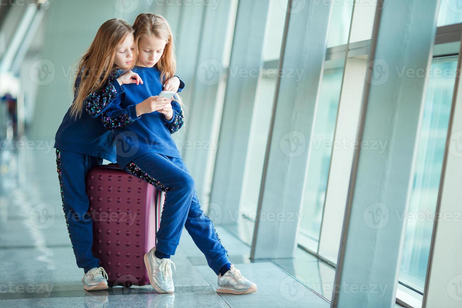 meninas adoráveis no aeroporto perto da grande janela foto