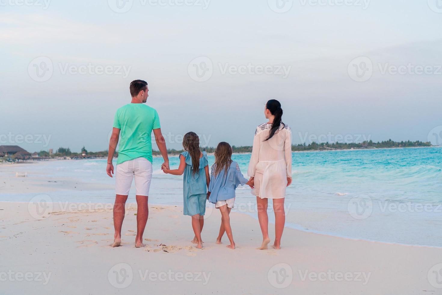 jovem família com dois filhos em férias na praia foto