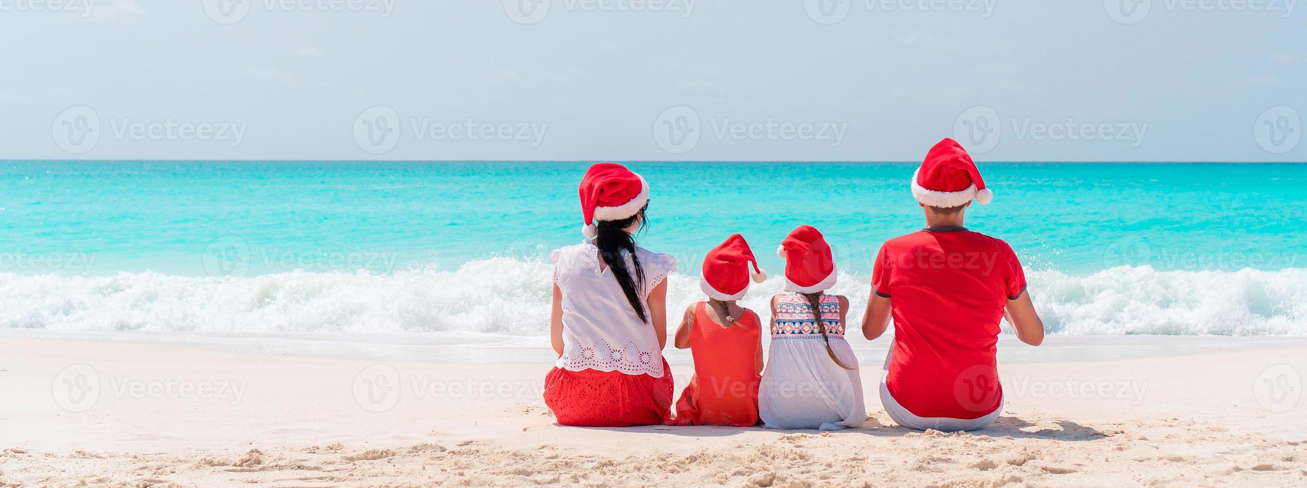 família feliz na praia do caribe comemorando as férias de natal foto