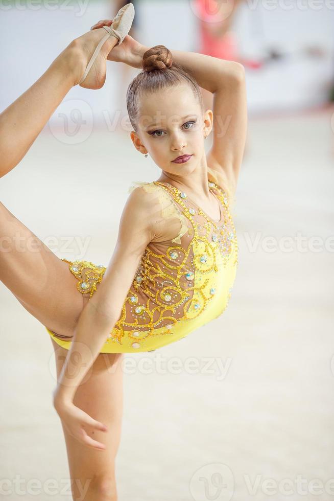 linda menina ginasta ativa com seu desempenho no tapete foto