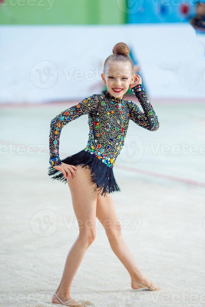 pequena ginasta treinando no tapete e pronta para competições foto