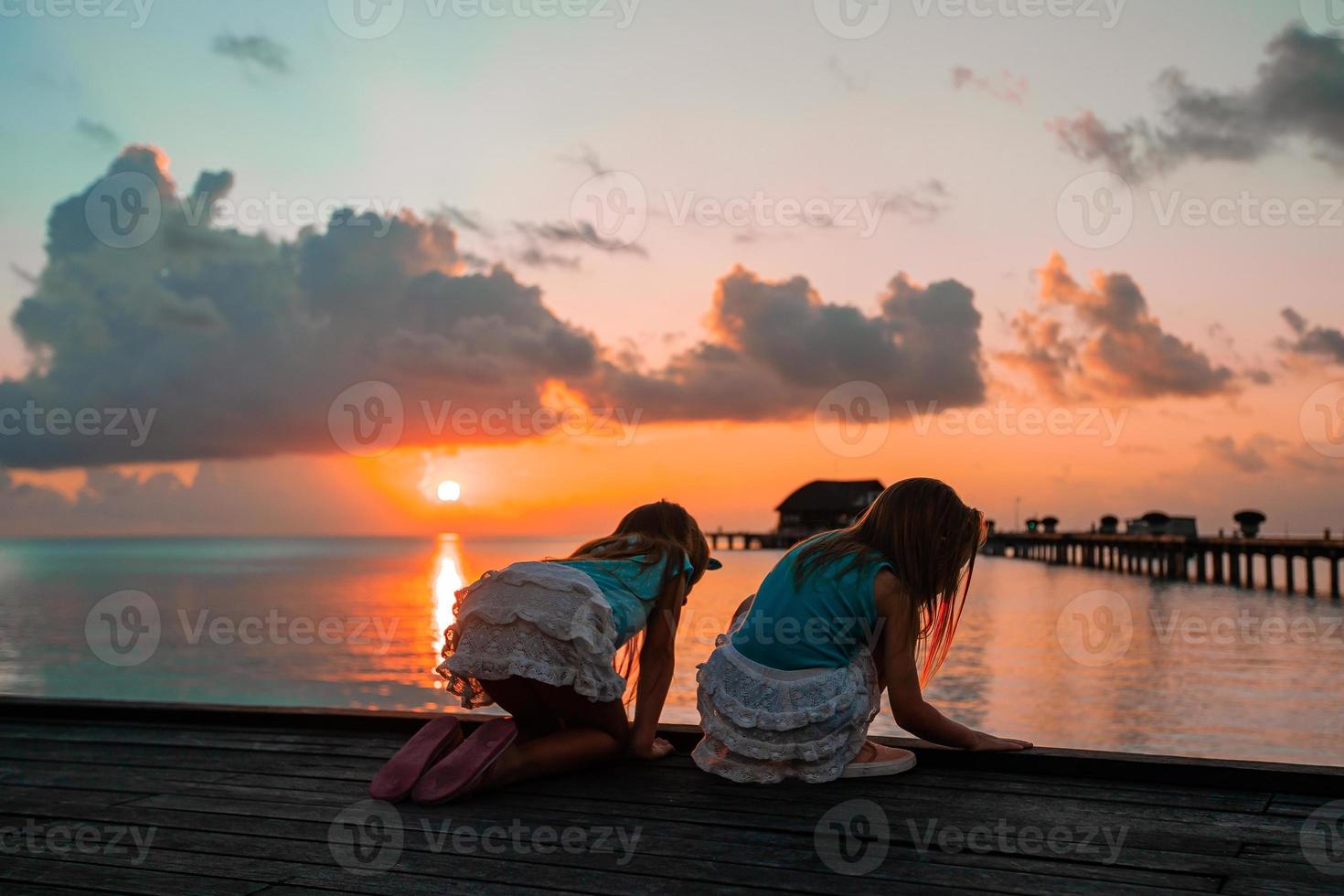 adoráveis meninas na praia ao pôr do sol foto