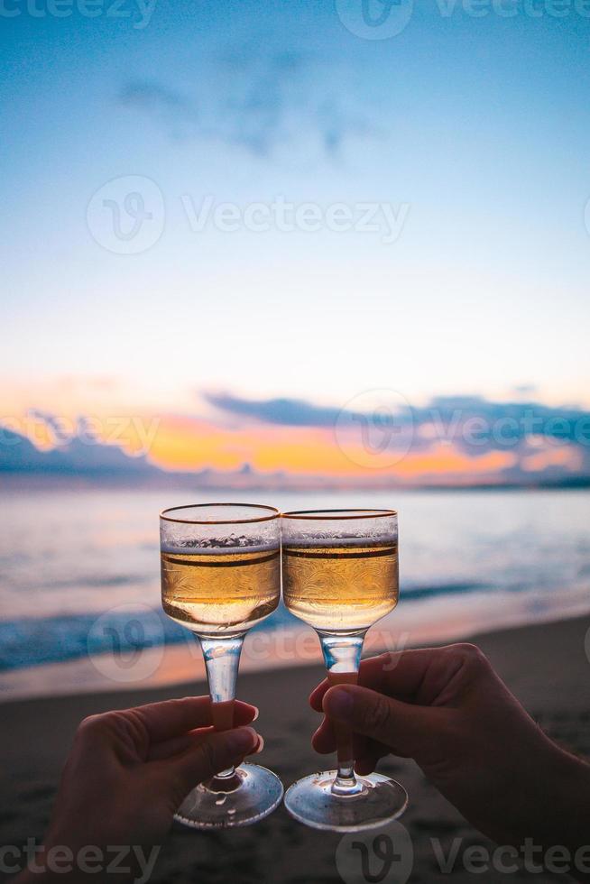 dois copos na praia de areia branca foto