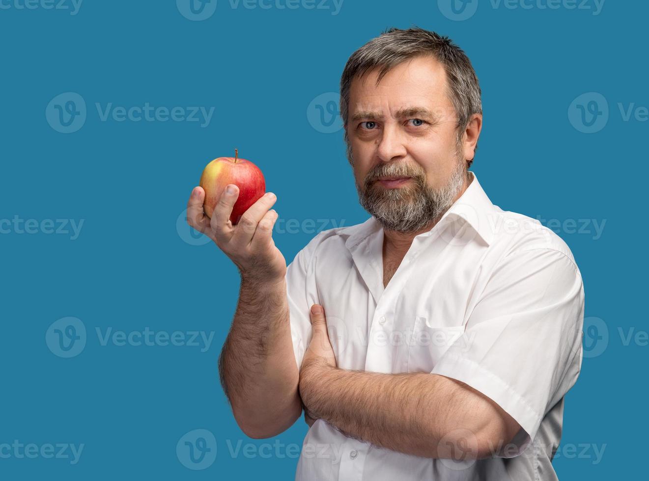homem de meia idade segurando uma maçã vermelha foto