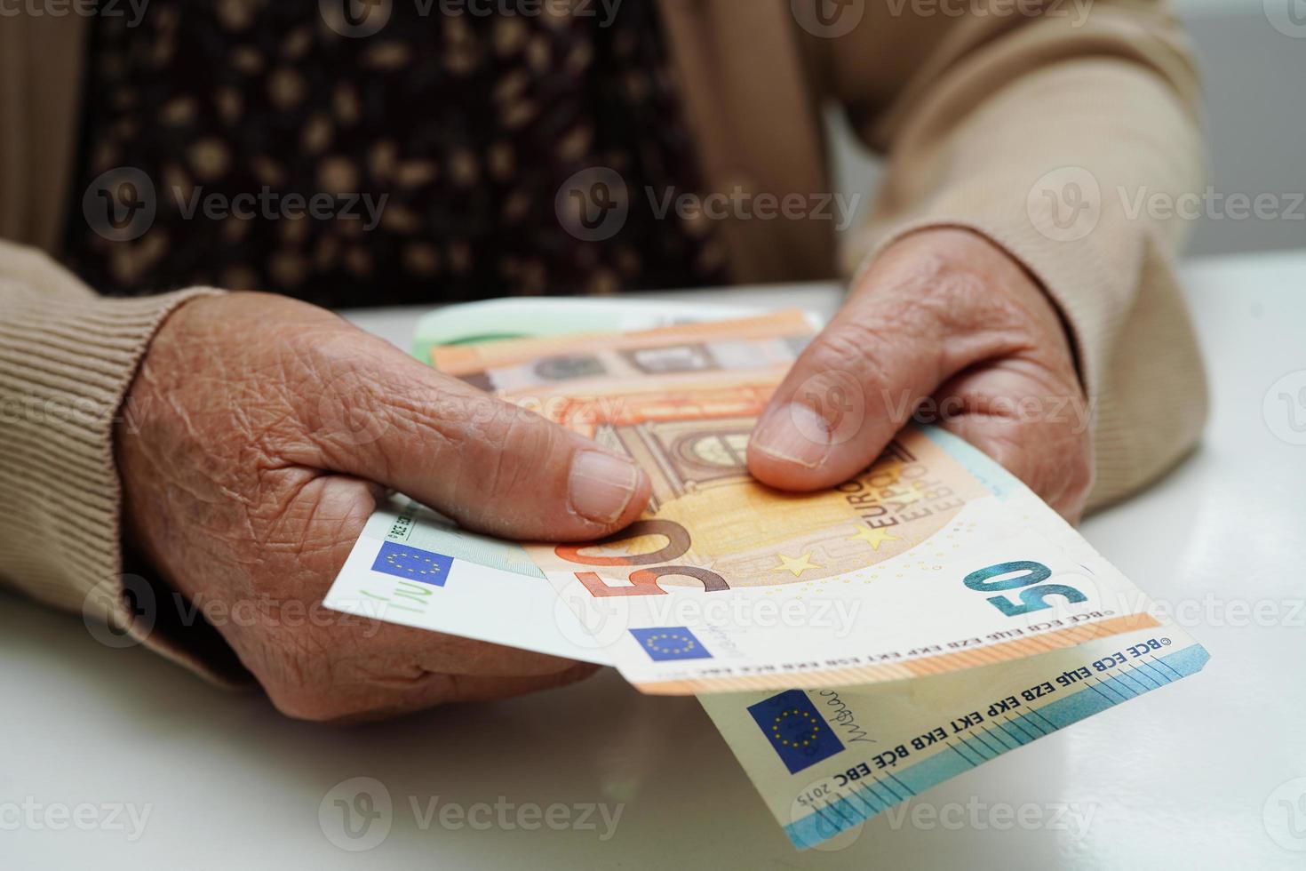 idosa aposentada segurando dinheiro de notas de euro e se preocupa com despesas mensais e pagamento de taxas de tratamento. foto
