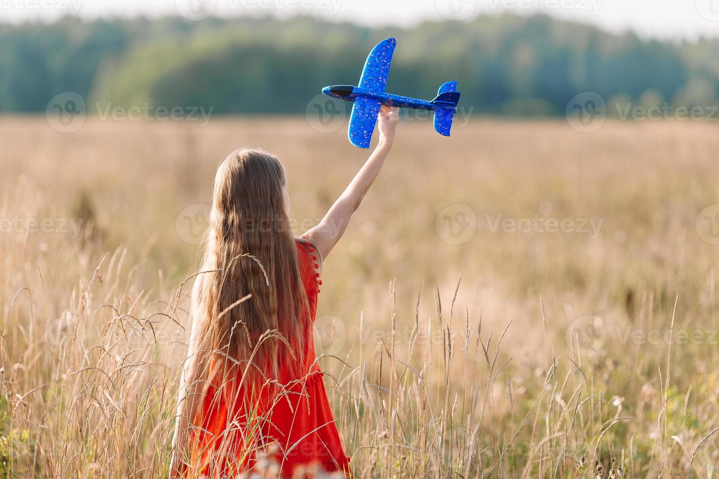 menina correndo rápido e segurando brinquedo de avião foto