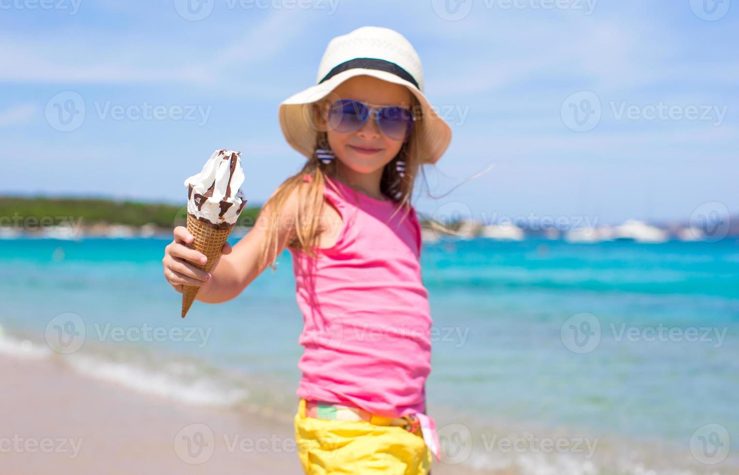 menina adorável com sorvete na praia tropical foto
