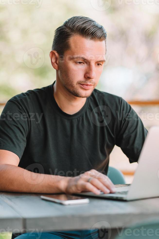 jovem com laptop trabalha em casa foto