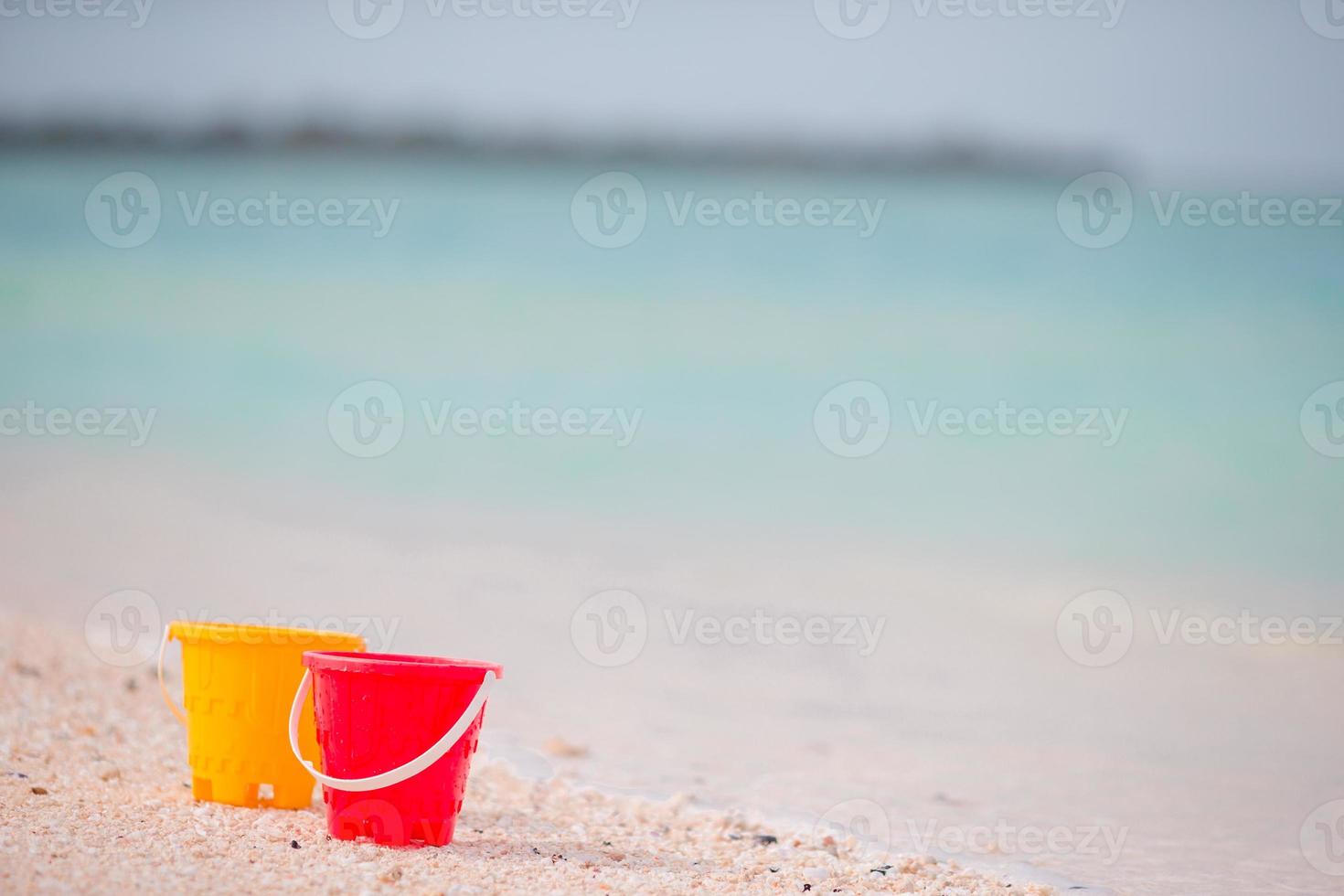 brinquedos de praia infantil na areia branca. baldes e lâminas para crianças na praia de areia branca após jogos infantis foto