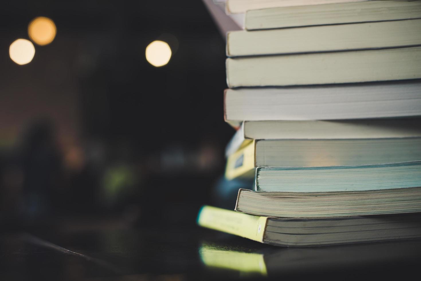 pilhas de livros em uma mesa sobre um fundo desfocado de biblioteca foto