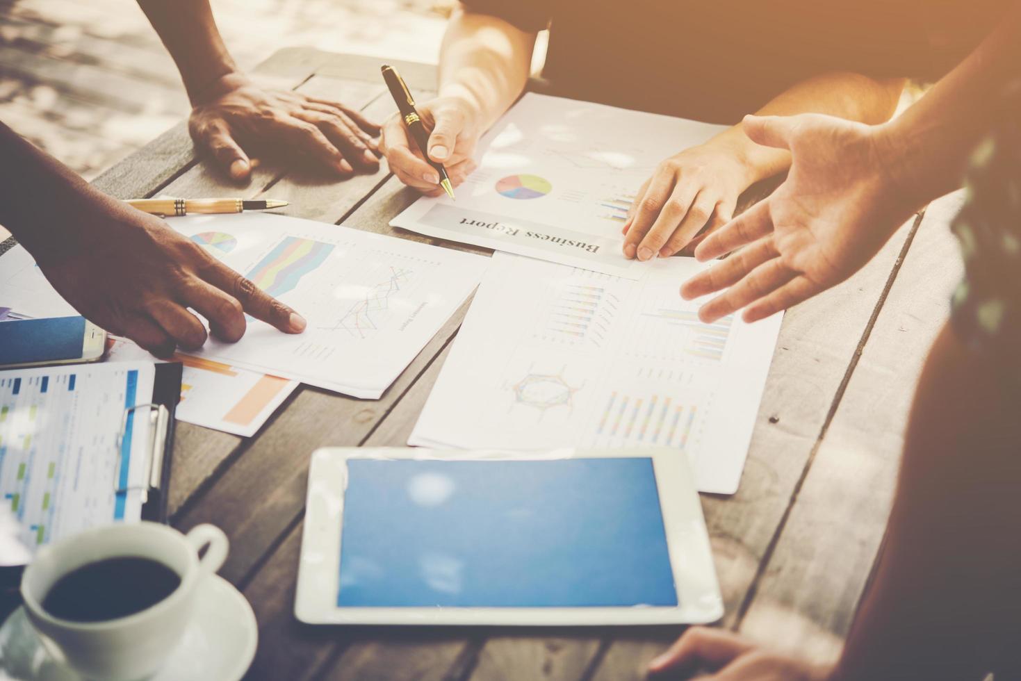 grupo de empresários analisa gráficos em reunião foto