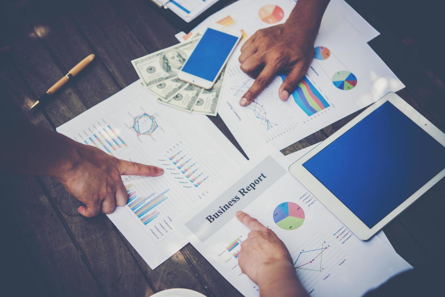 grupo de empresários analisa gráficos em reunião foto