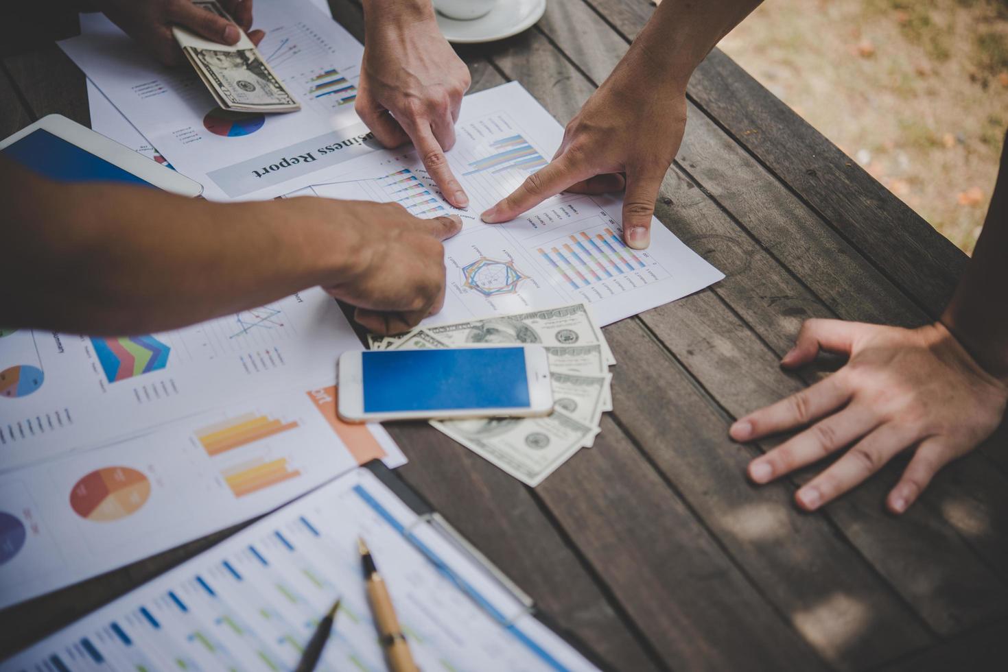 grupo de empresários analisa gráficos em reunião foto