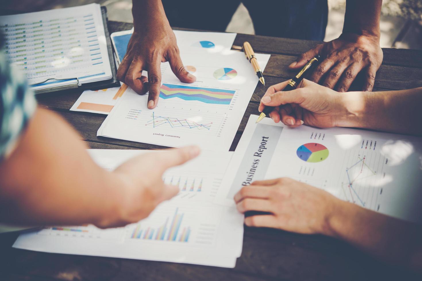 grupo de empresários analisa gráficos em reunião foto