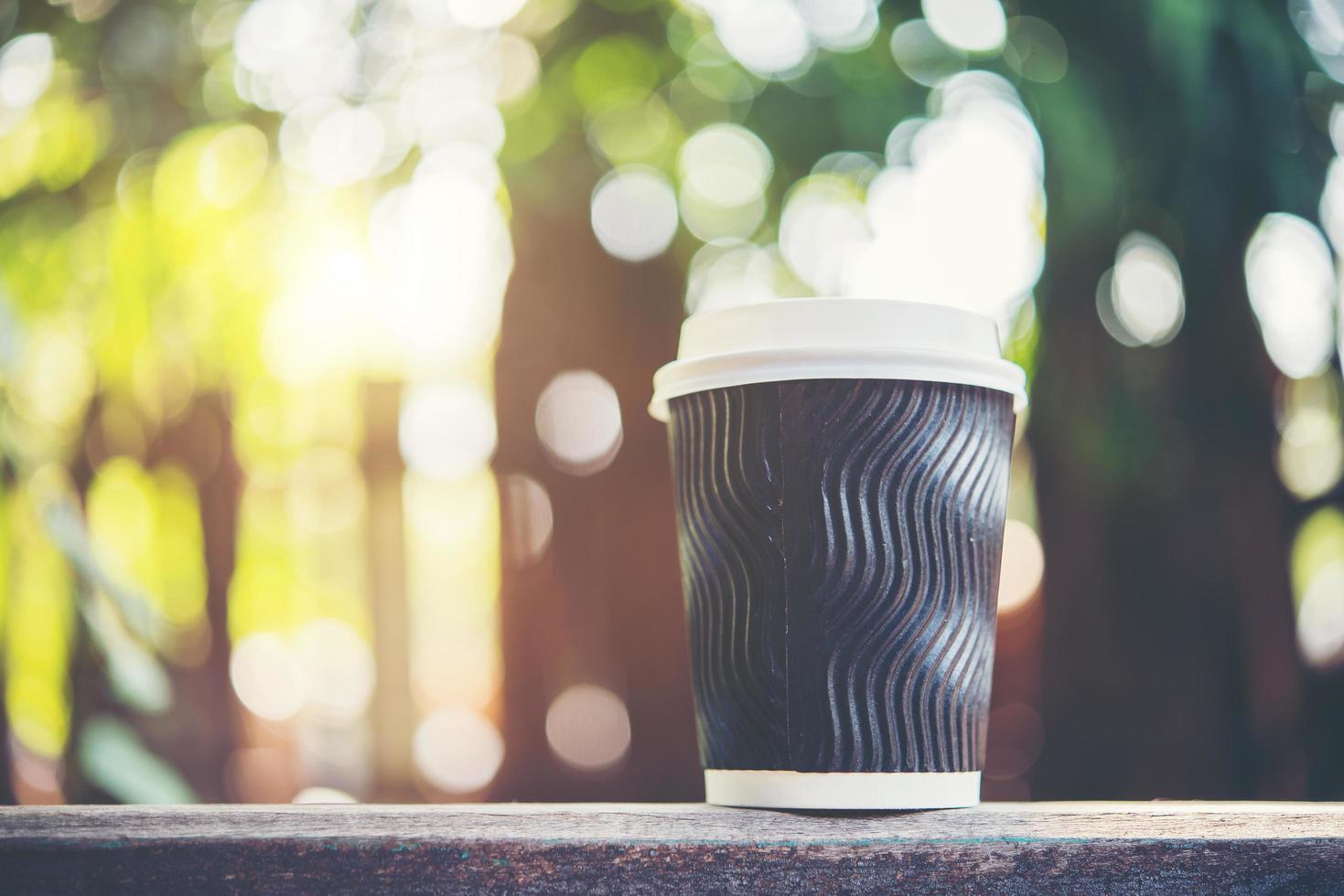 xícara de café de papel em fundo natural de manhã foto