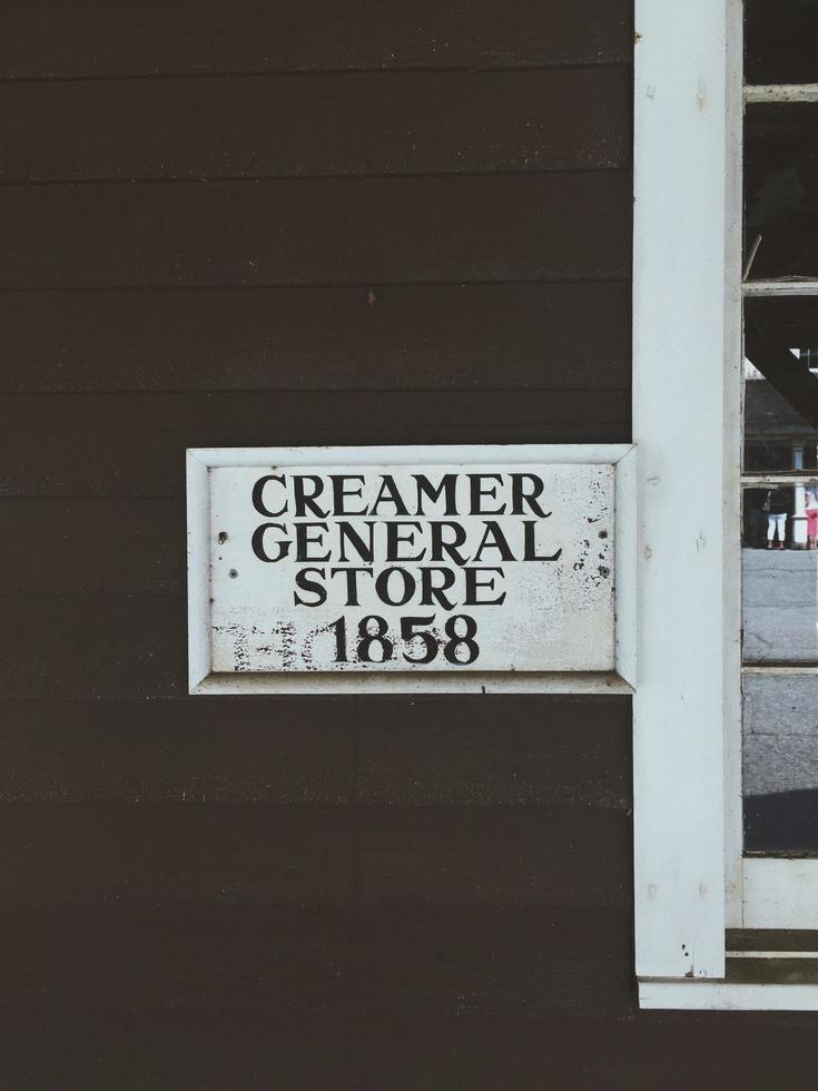 Sinalização de loja geral de creme de leite de 1858 na parede de madeira foto