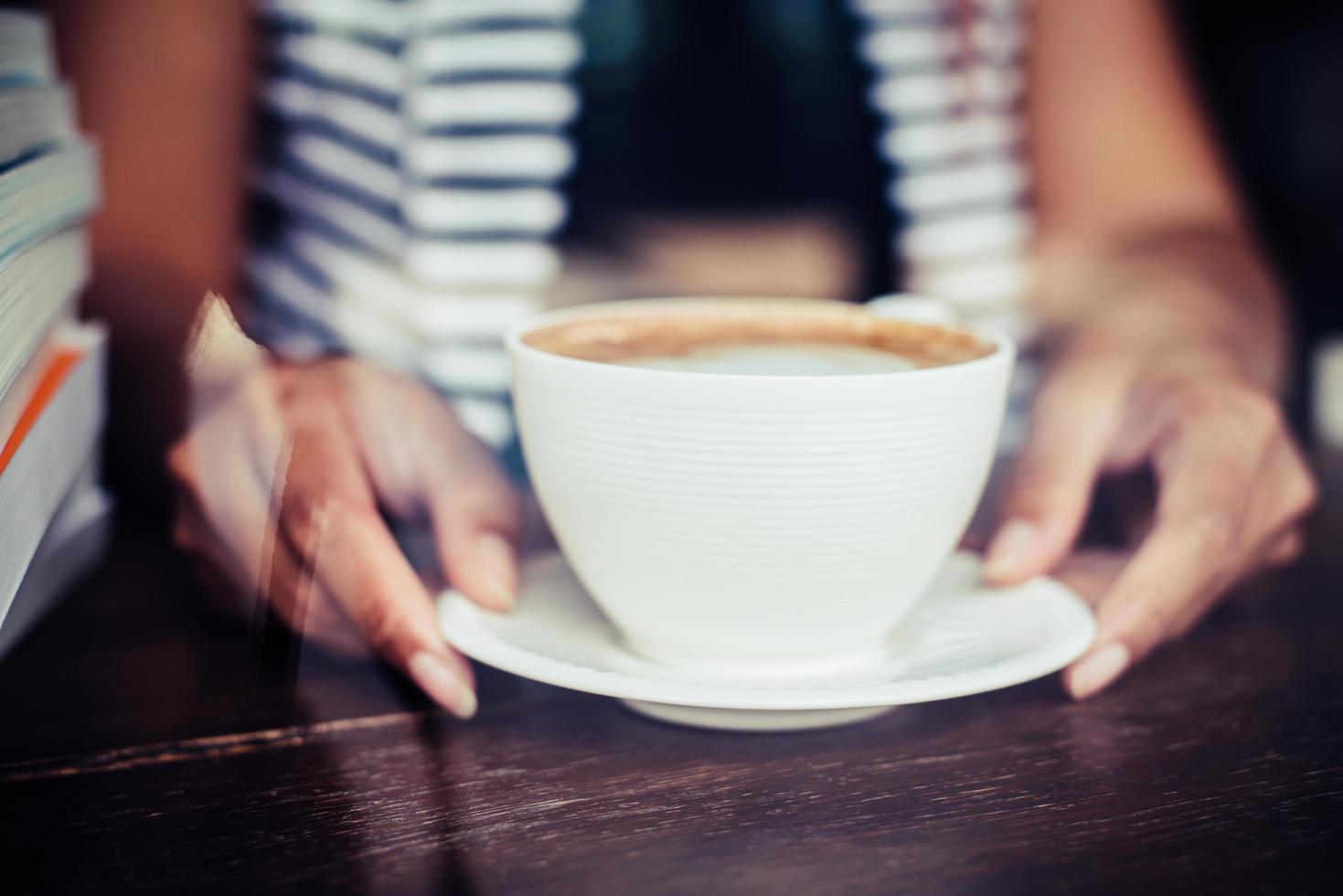mãos de mulher relaxando com café no café foto