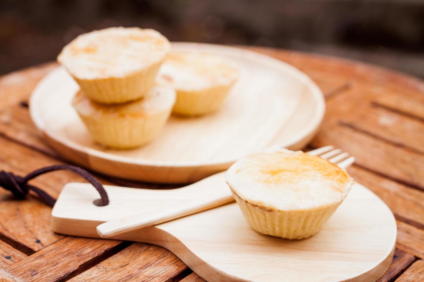 Mini tortas em um prato de madeira e bandeja foto