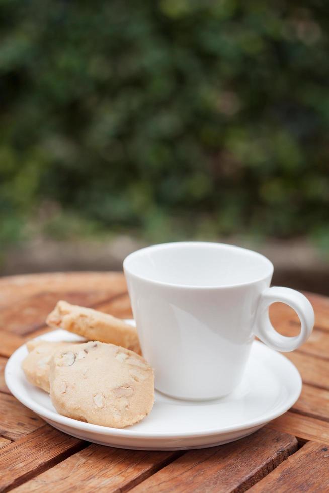 biscoitos de caju com uma xícara de café branco foto
