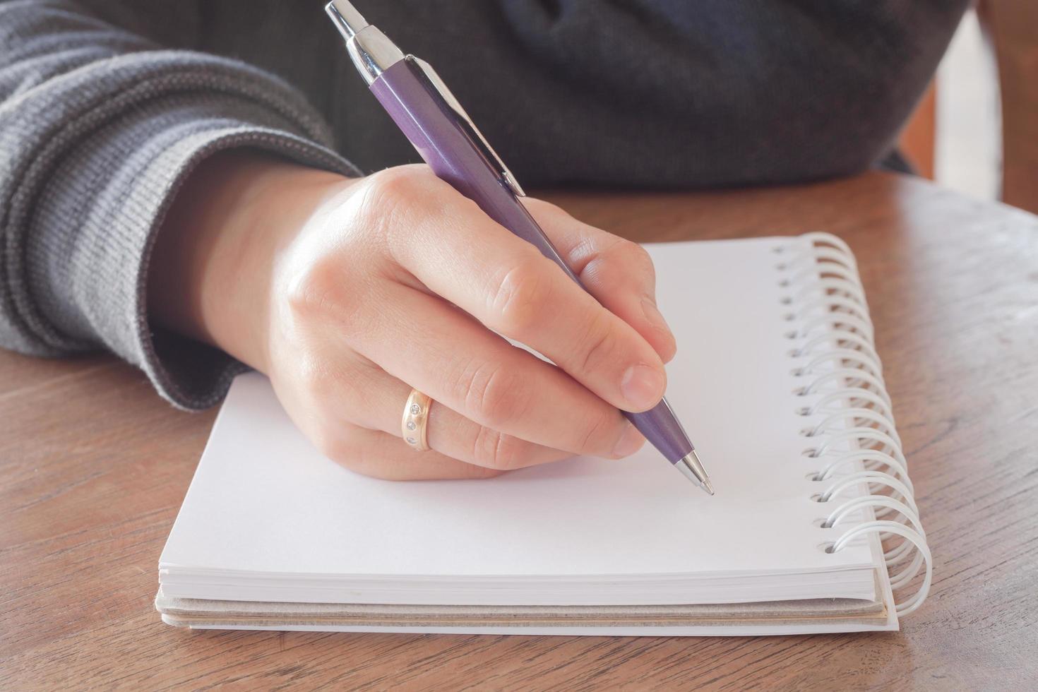 close-up de uma pessoa escrevendo em um caderno foto
