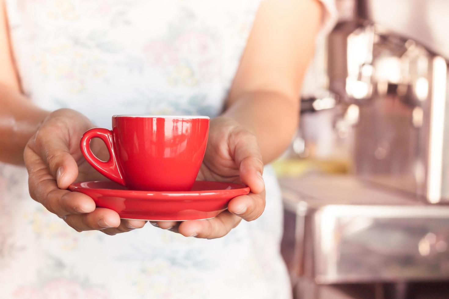 mulher segurando uma xícara de café vermelha foto