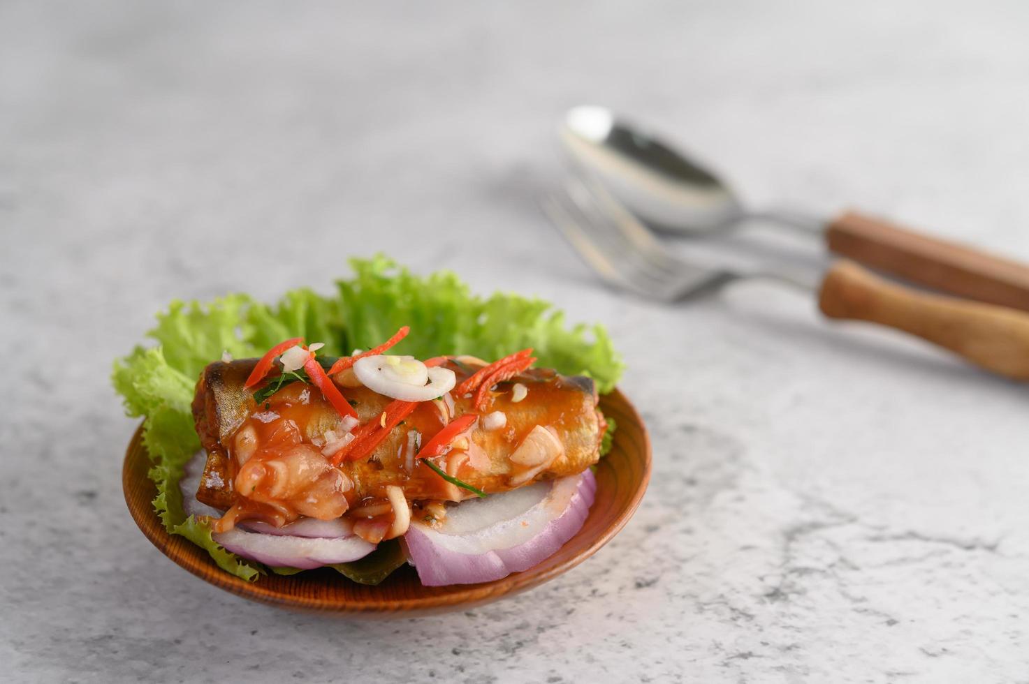 salada picante de sardinha em tigela de madeira foto