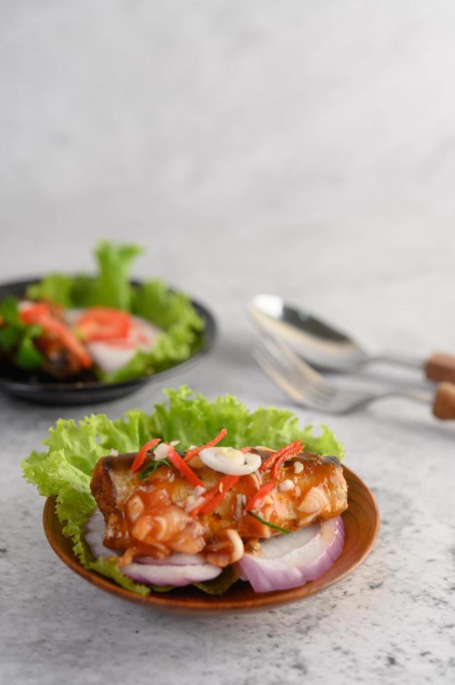 salada picante de sardinha em tigela de madeira foto