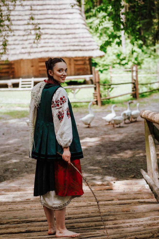 linda garota em um vestido bordado tradicional andando descalça foto