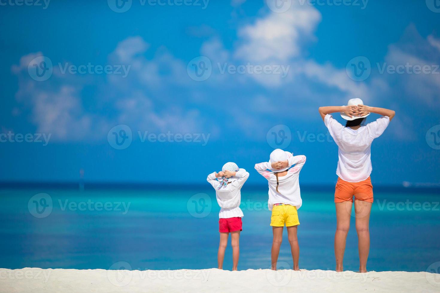 adoráveis meninas e jovem mãe na praia tropical branca foto