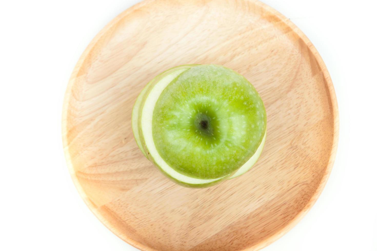 vista superior de uma maçã verde em uma placa de madeira foto