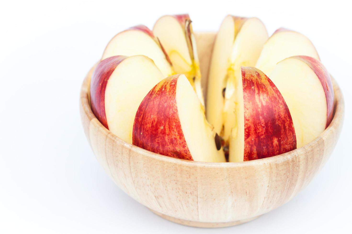 maçã cortada em uma tigela de madeira foto