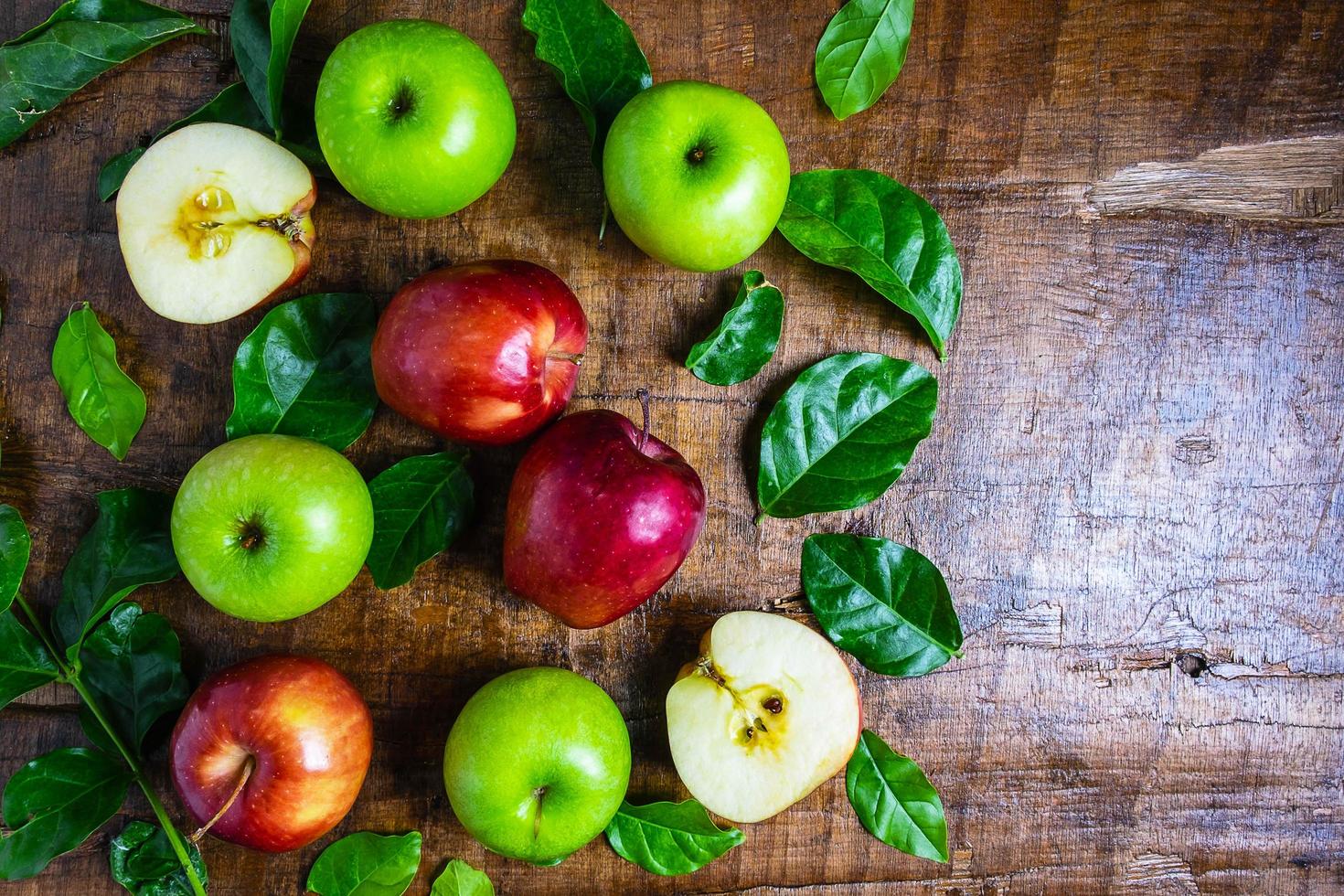 maçãs e folhas em uma mesa foto