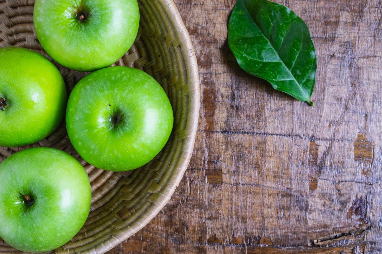 vista superior de maçãs verdes em uma cesta foto