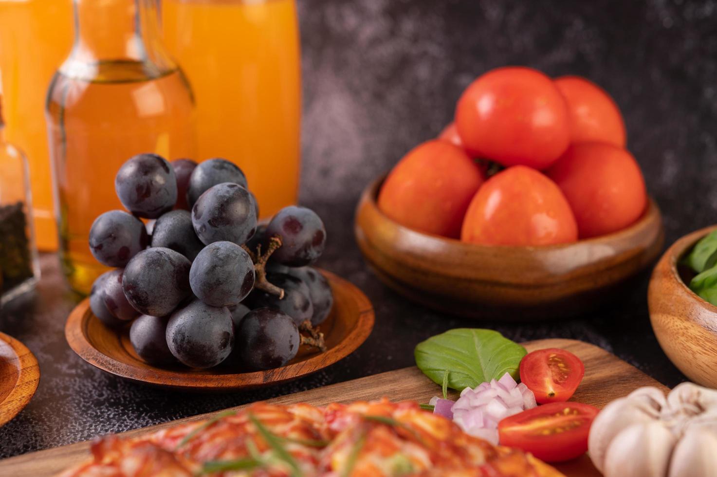 uvas pretas com tomate suco de laranja e pizza foto