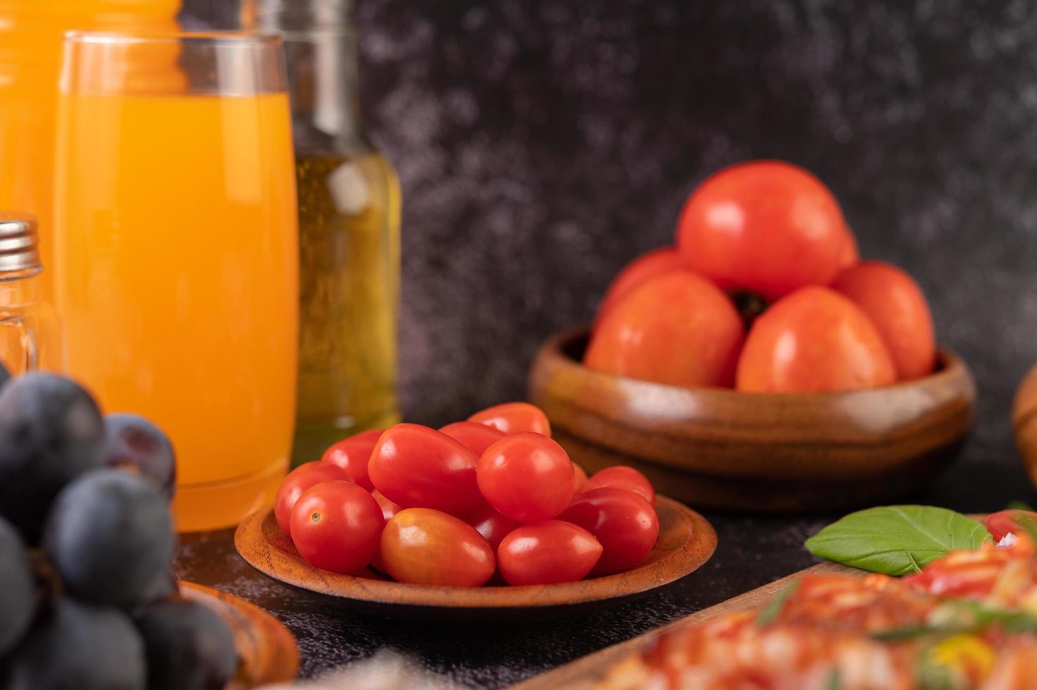 tomates frescos, uvas e suco de laranja em um copo foto