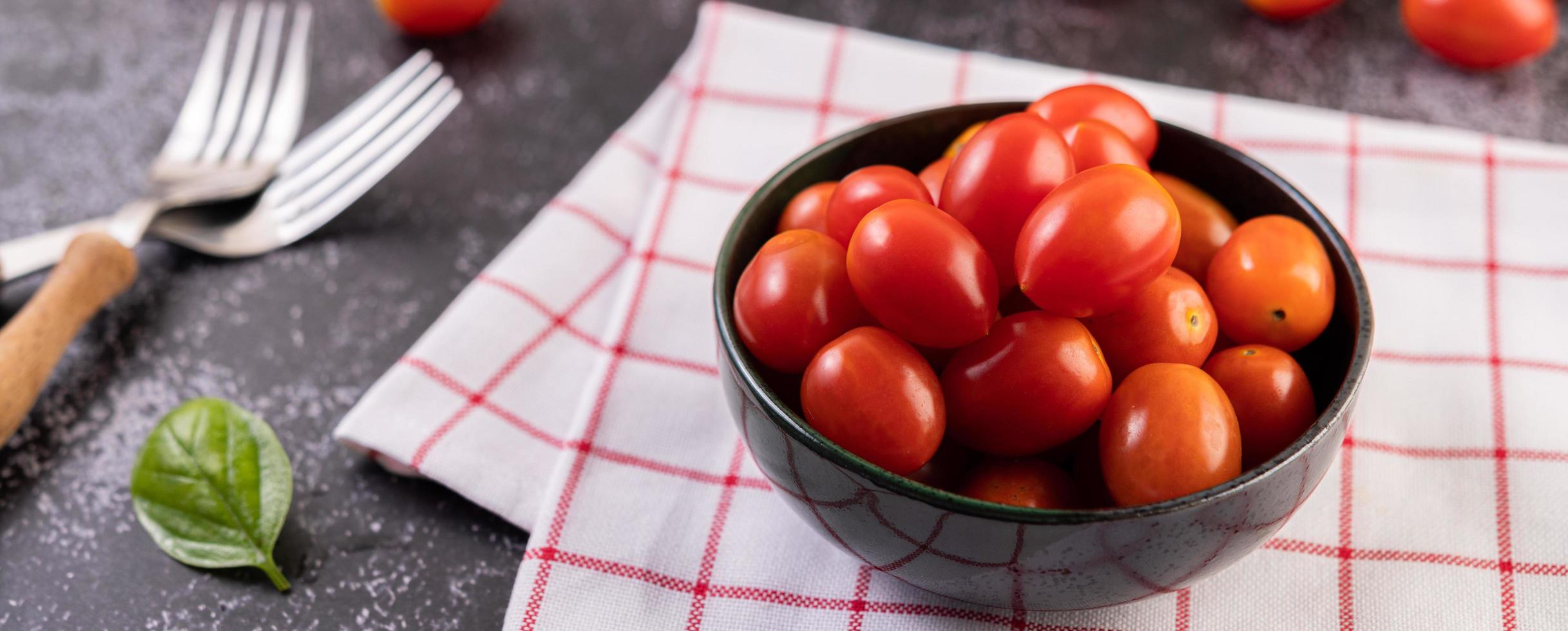 tomates maduros frescos em um pano xadrez vermelho foto