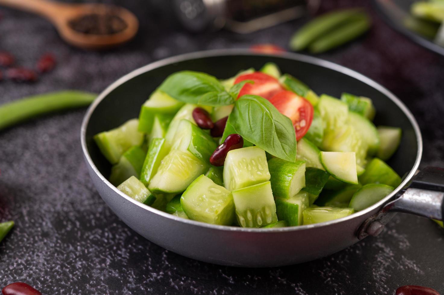 pepinos com tomates em uma panela foto