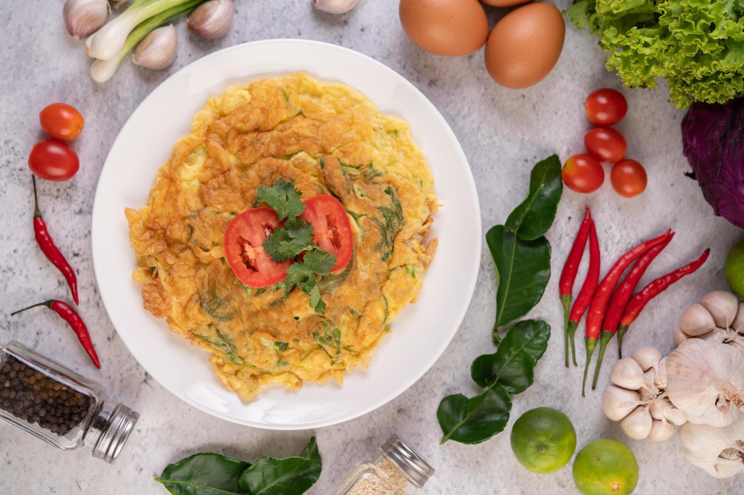 omelete em um prato branco com tomate foto