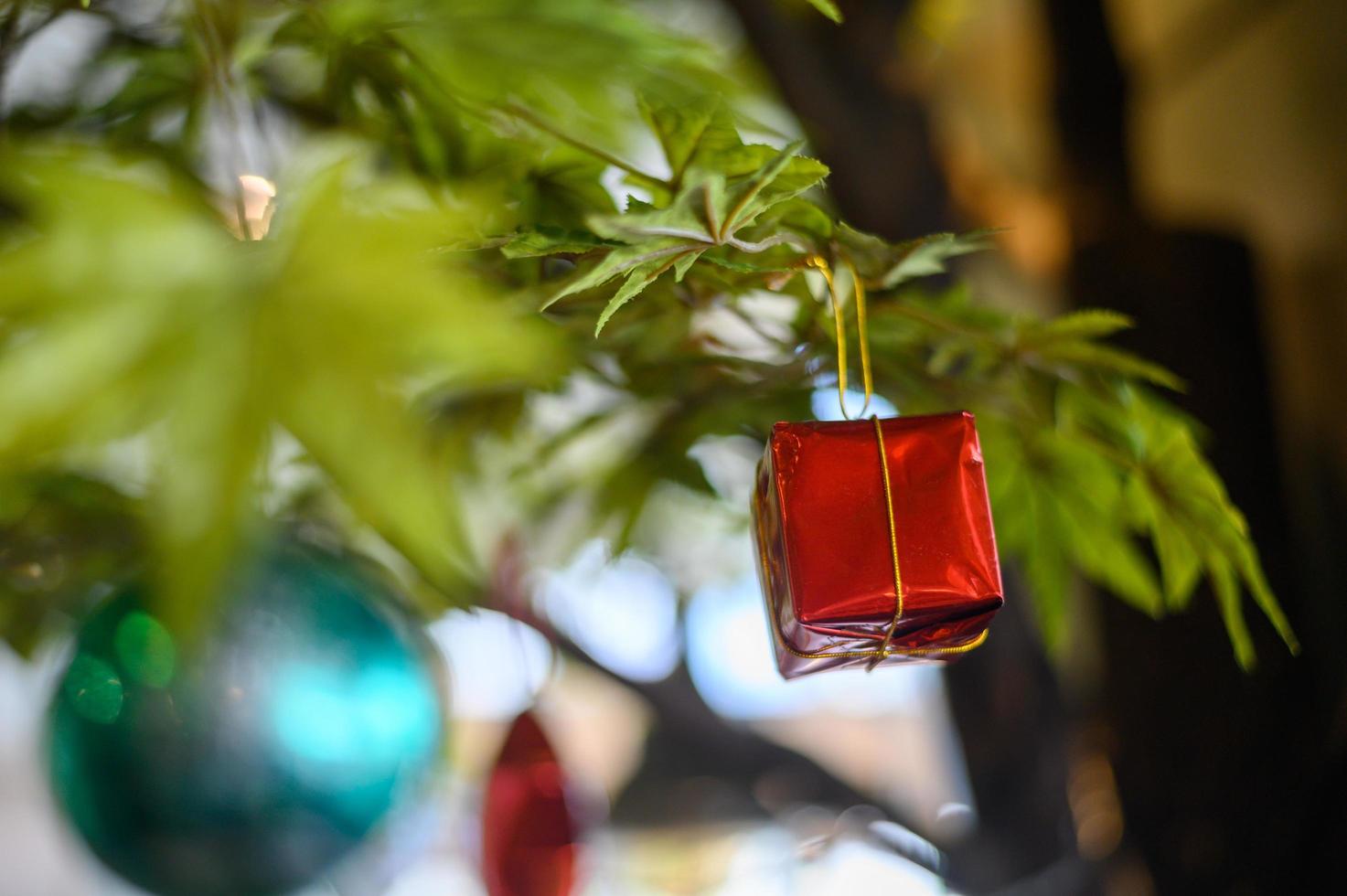 close-up de um enfeite de caixa de presente pendurado na árvore de natal foto