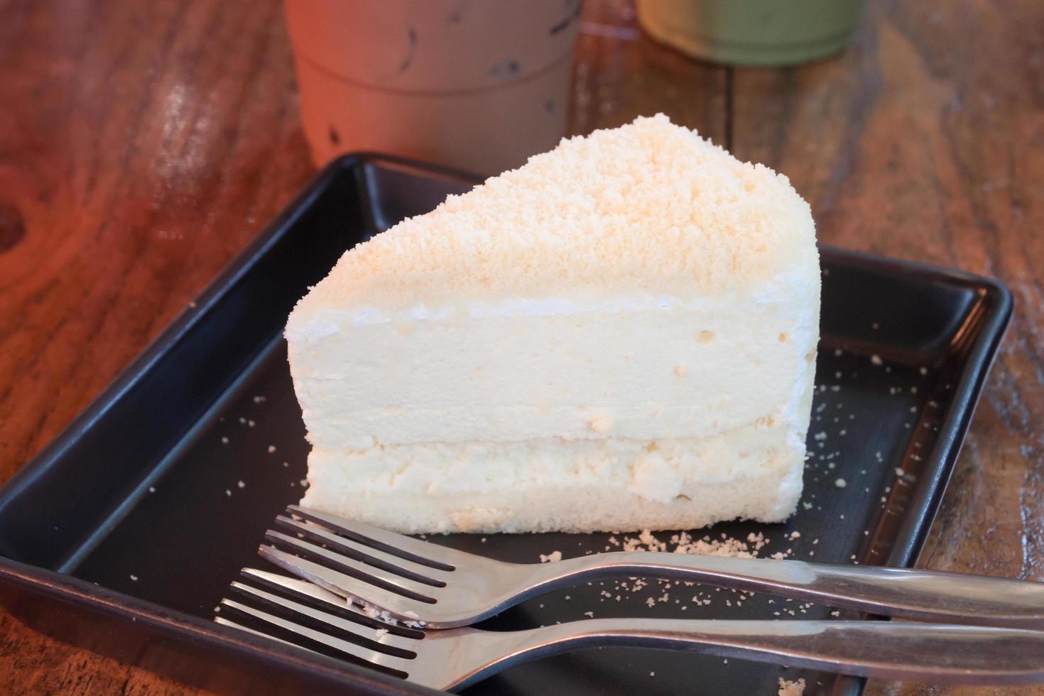 bolo branco em um prato preto foto