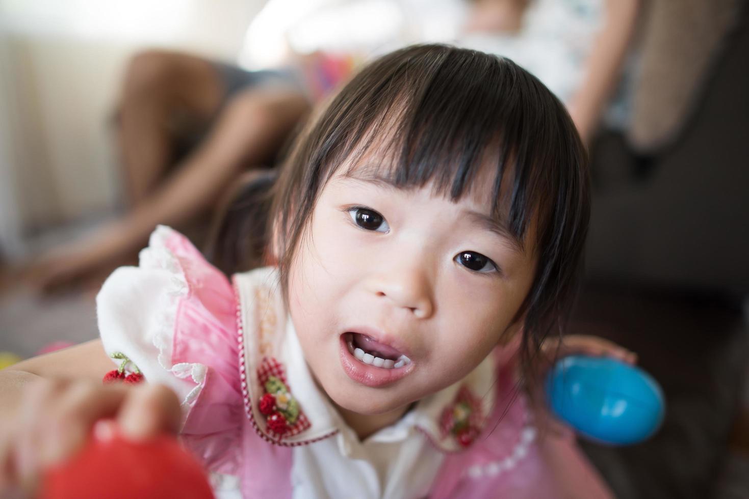 retrato de uma menina asiática brincando em sua casa foto