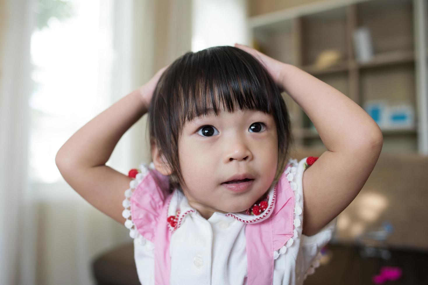 retrato de uma menina asiática brincando em sua casa foto