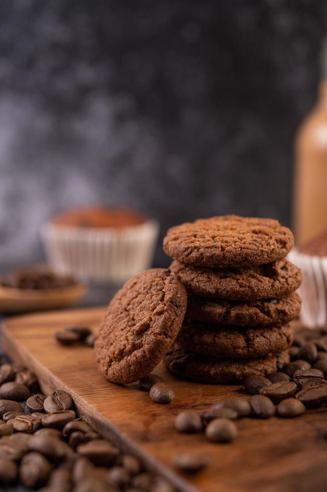 biscoitos com grãos de café em uma placa de madeira foto