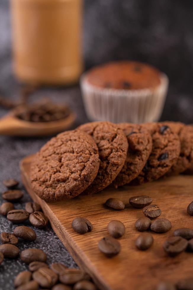 biscoitos com grãos de café em uma placa de madeira foto
