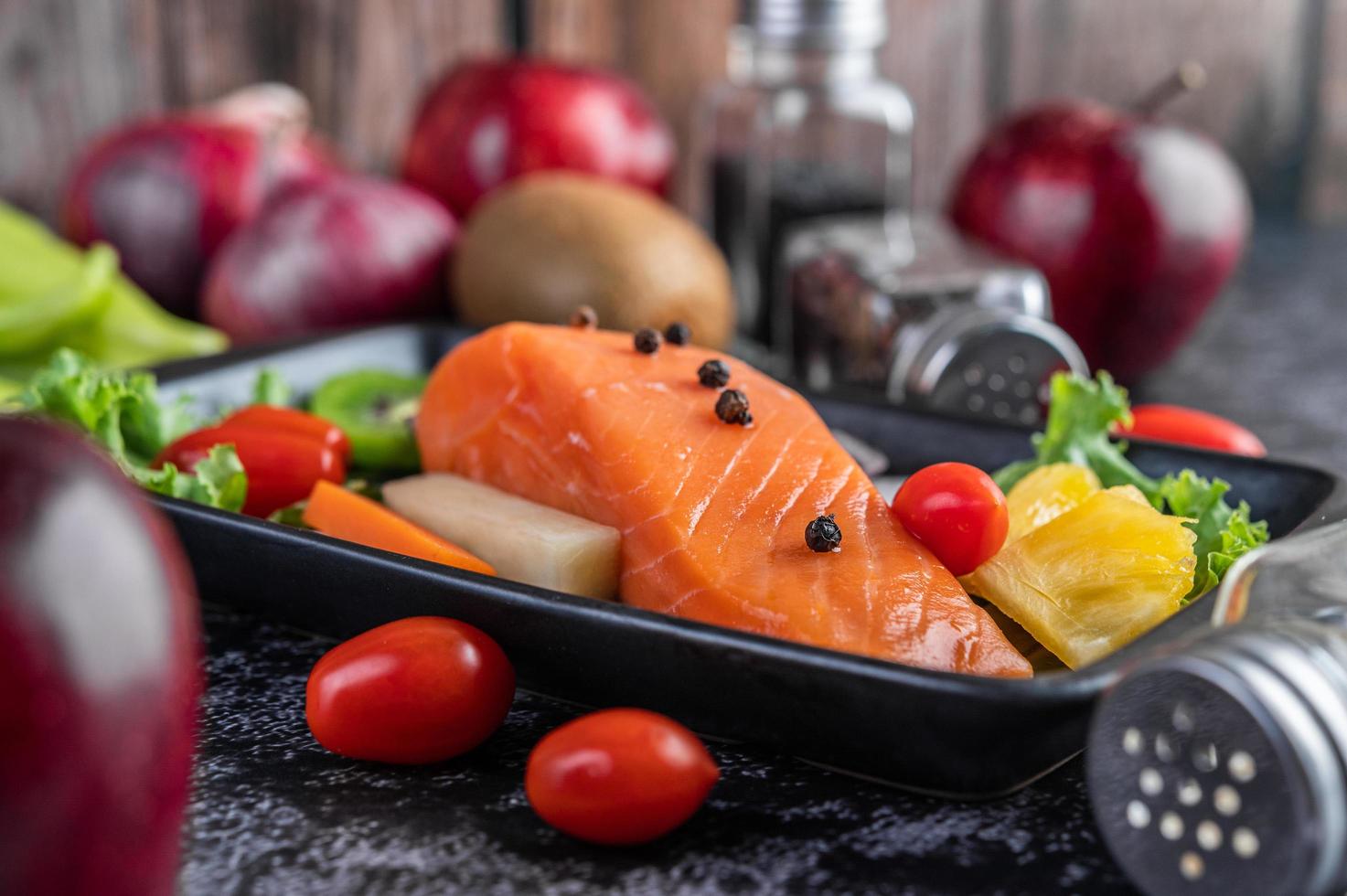 filé de salmão cru com pimenta, kiwi, abacaxi e alecrim foto