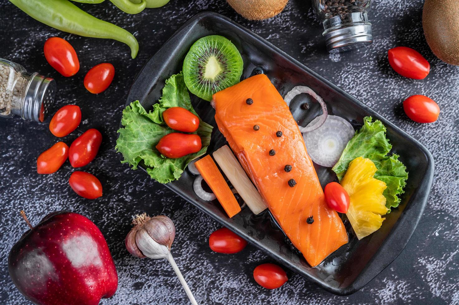 filé de salmão cru com pimenta, kiwi, abacaxi e alecrim foto