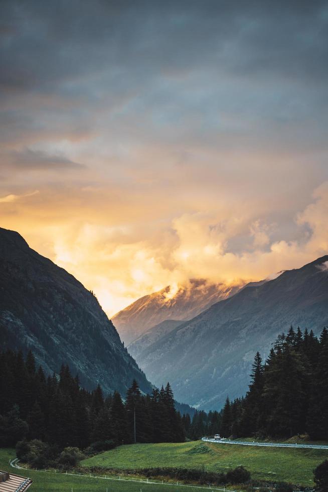 pôr do sol através das nuvens perto das montanhas foto